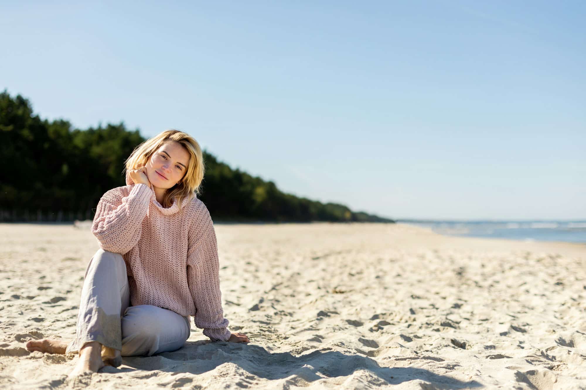 Happy woman on beach during cold spring weather